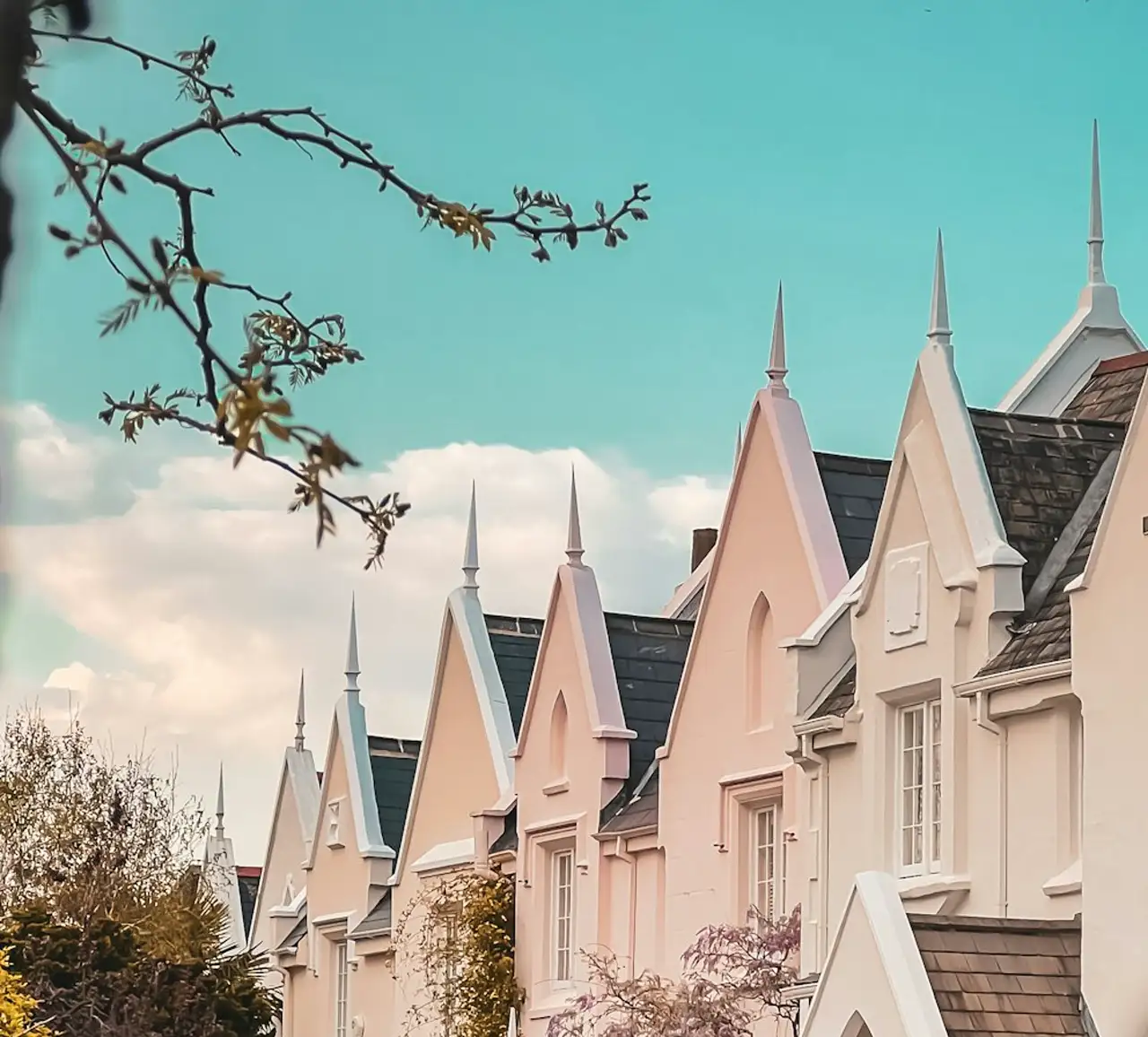 Stock photograph: a row of pale gabled houses under a blue sky. Not a MaintenanceOS customer estate or live portfolio.